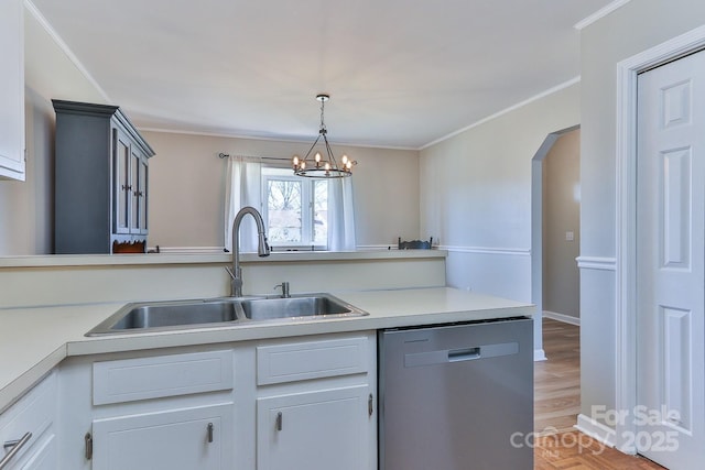 kitchen featuring a sink, hanging light fixtures, light countertops, stainless steel dishwasher, and crown molding