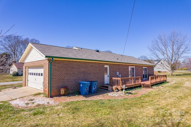 back of house with brick siding, concrete driveway, a wooden deck, a lawn, and a garage