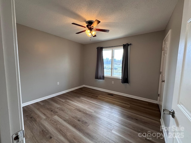 spare room featuring ceiling fan, a textured ceiling, baseboards, and wood finished floors