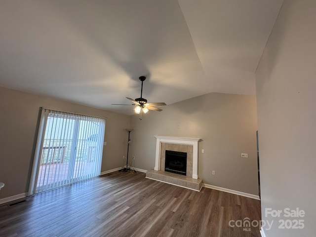 unfurnished living room with visible vents, baseboards, dark wood finished floors, vaulted ceiling, and a tiled fireplace