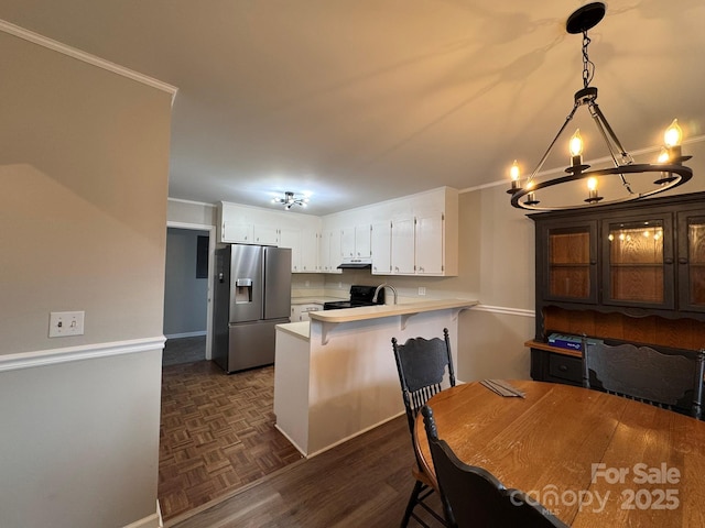 kitchen with a peninsula, light countertops, black range with electric cooktop, stainless steel refrigerator with ice dispenser, and white cabinetry