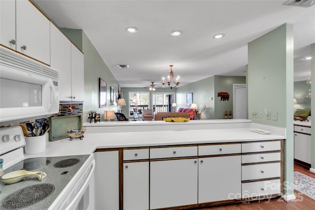 kitchen with white cabinetry, white appliances, a notable chandelier, and light countertops