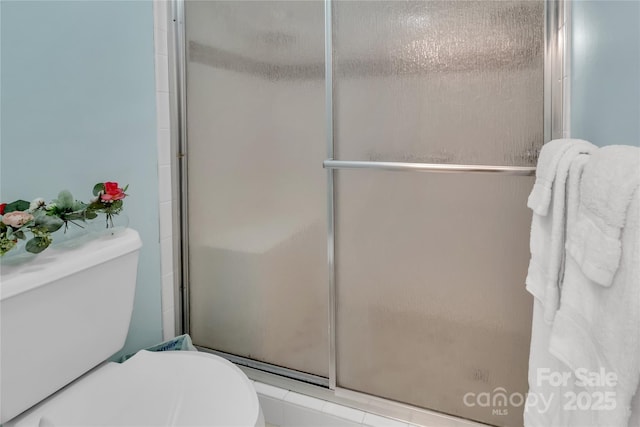 full bathroom featuring a stall shower and toilet