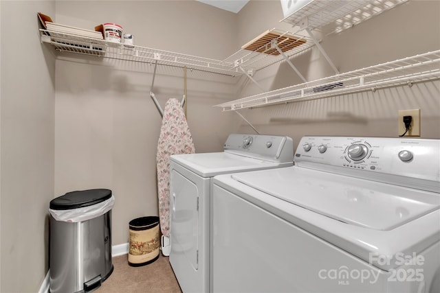 laundry room with washer and dryer, laundry area, light colored carpet, and baseboards