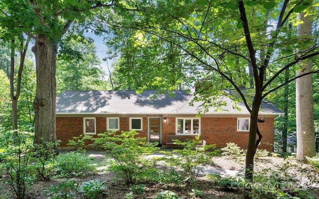 single story home with brick siding and a shingled roof