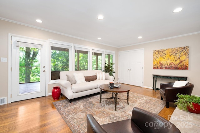 living room featuring recessed lighting, ornamental molding, and wood finished floors