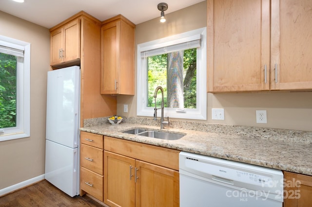 kitchen featuring white appliances, light stone countertops, baseboards, a sink, and dark wood-type flooring