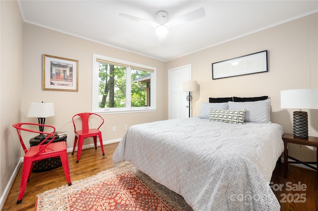 bedroom with ceiling fan, crown molding, baseboards, and wood finished floors