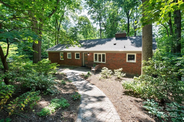 ranch-style home with brick siding and a chimney