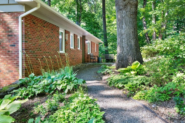 view of property exterior with brick siding and driveway