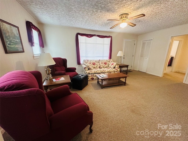 living room with a textured ceiling, carpet floors, and a ceiling fan