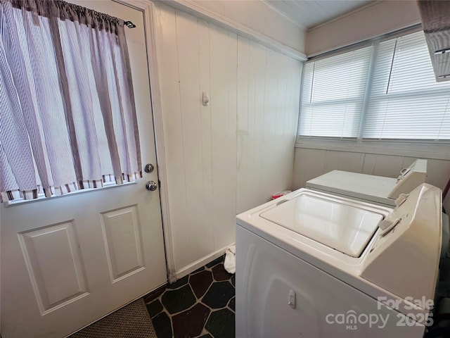 laundry area featuring wooden walls, laundry area, and washer and clothes dryer