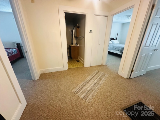 corridor with carpet floors and baseboards