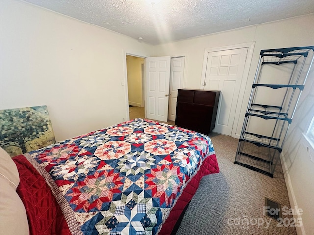 bedroom featuring a textured ceiling and carpet flooring