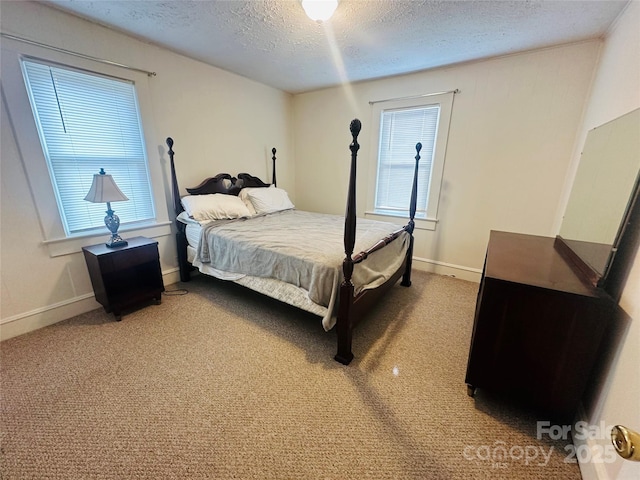 carpeted bedroom featuring a textured ceiling and baseboards