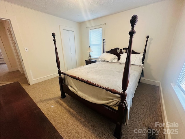 carpeted bedroom featuring a textured ceiling and baseboards