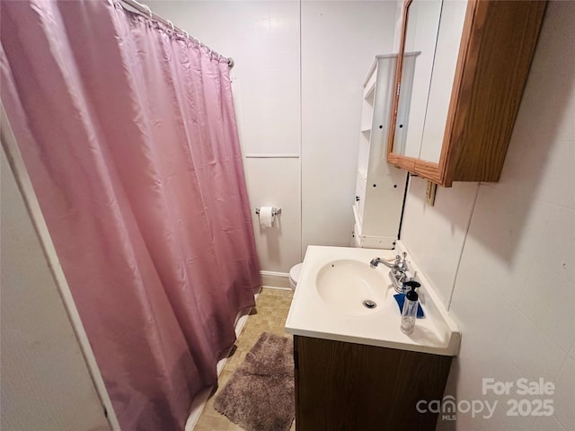 full bathroom featuring toilet, vanity, and a shower with curtain