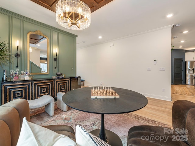 dining area with crown molding, baseboards, light wood-type flooring, recessed lighting, and a notable chandelier