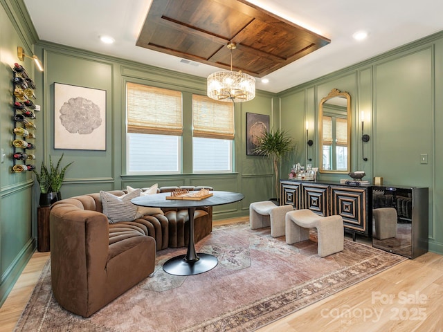 bathroom featuring visible vents, wood finished floors, crown molding, and a decorative wall