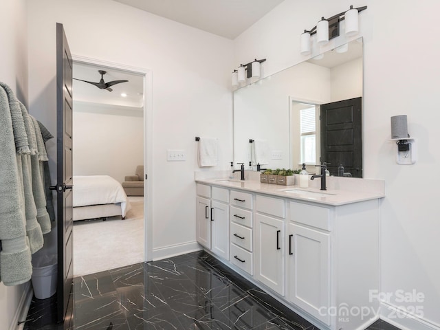 ensuite bathroom with baseboards, double vanity, a sink, ensuite bathroom, and marble finish floor