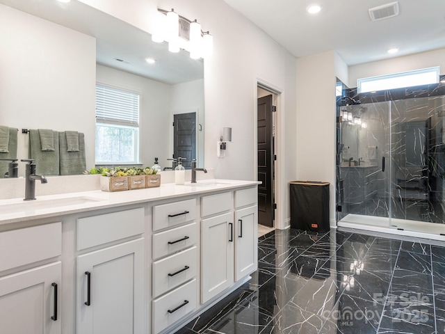 bathroom featuring a marble finish shower, visible vents, marble finish floor, and a sink