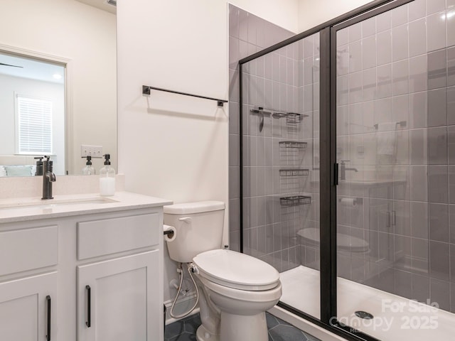 full bathroom featuring vanity, toilet, and a stall shower