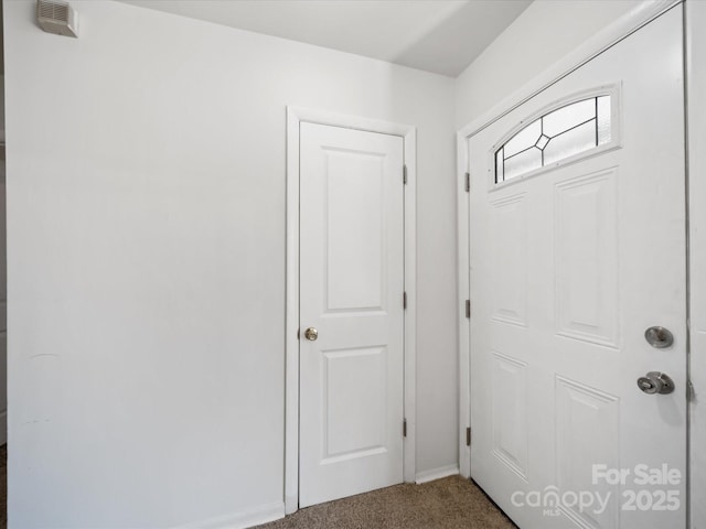 carpeted foyer entrance with baseboards