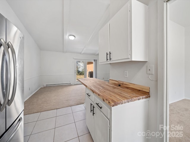 kitchen featuring a baseboard heating unit, open floor plan, light carpet, freestanding refrigerator, and white cabinets