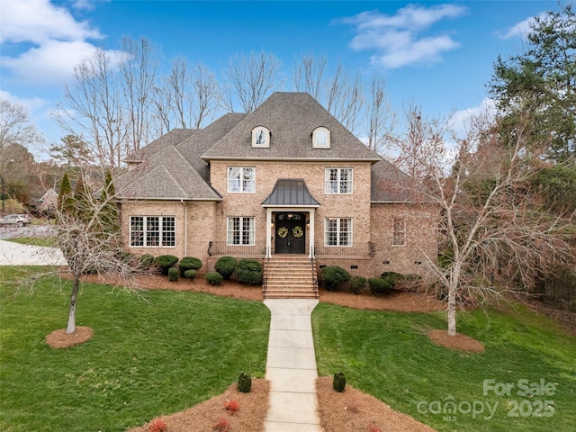 french provincial home featuring a shingled roof, a front yard, brick siding, and crawl space