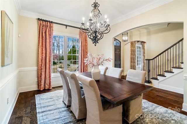 dining room featuring stairway, wood finished floors, arched walkways, crown molding, and a chandelier