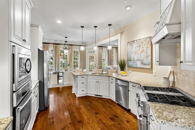 kitchen featuring custom range hood, ornamental molding, a peninsula, stainless steel appliances, and a sink