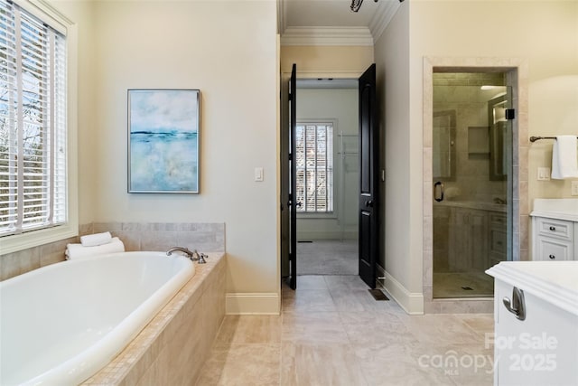 bathroom with vanity, baseboards, ornamental molding, a shower stall, and a bath