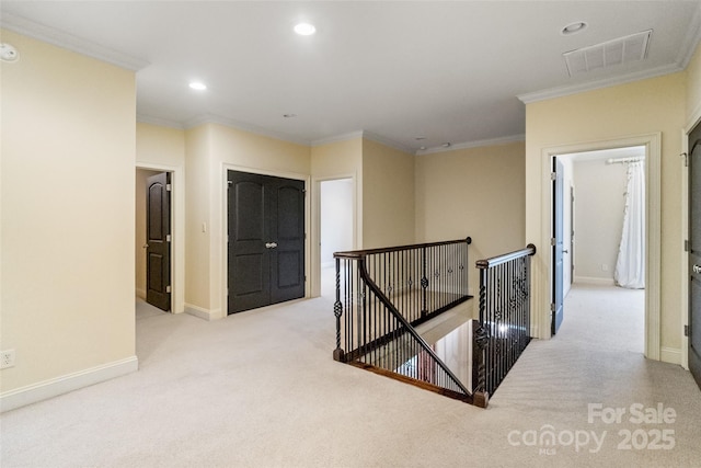 corridor featuring visible vents, ornamental molding, an upstairs landing, carpet flooring, and recessed lighting