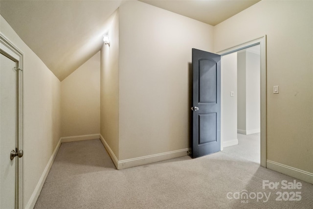 additional living space featuring vaulted ceiling, carpet, and baseboards