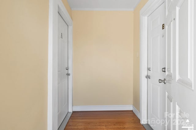 corridor with baseboards and wood finished floors