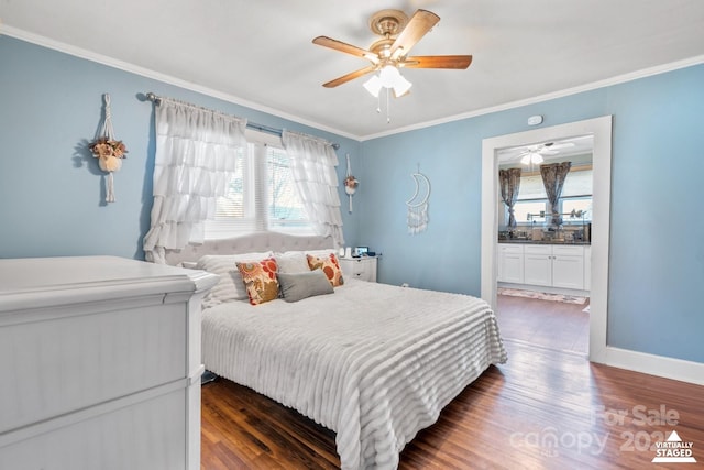 bedroom with baseboards, dark wood finished floors, a ceiling fan, ensuite bath, and crown molding