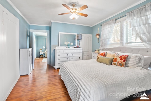 bedroom featuring ceiling fan, a closet, crown molding, and wood finished floors
