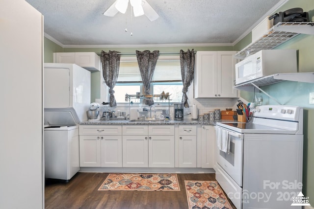 kitchen with white appliances, a sink, white cabinets, ornamental molding, and dark wood-style floors