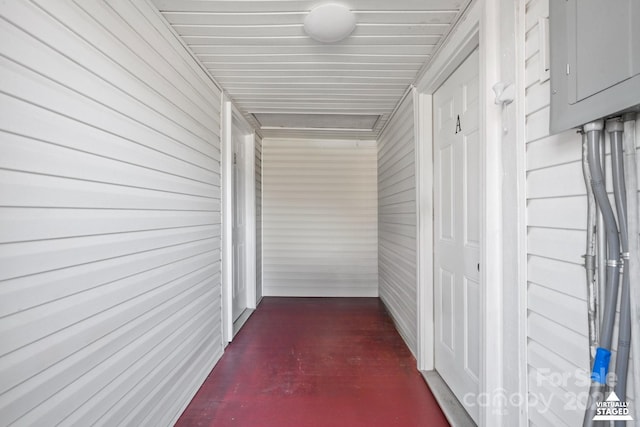 hall featuring electric panel and concrete flooring