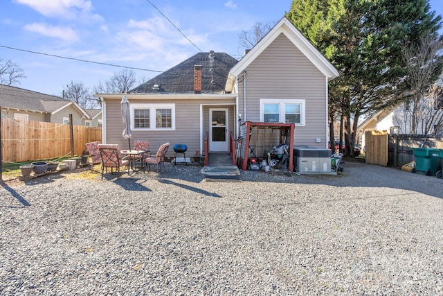 back of house with a patio, a chimney, entry steps, fence, and a jacuzzi