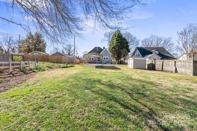 view of yard featuring an outbuilding, a shed, and a fenced backyard