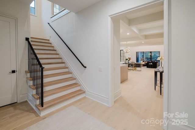 stairs featuring a notable chandelier, wood finished floors, recessed lighting, and baseboards