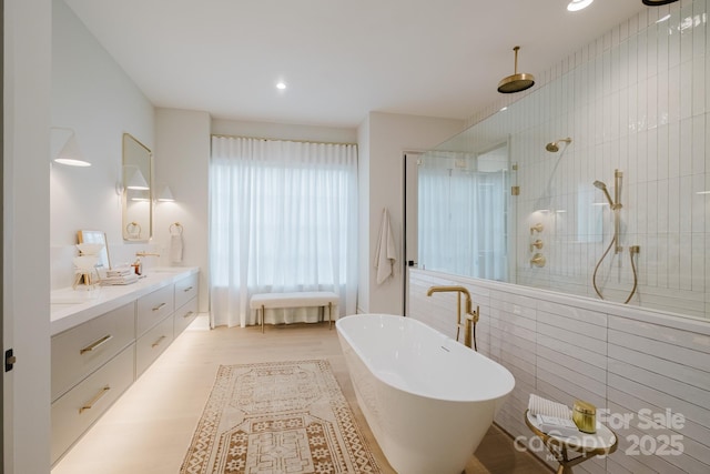 bathroom with a soaking tub, walk in shower, and double vanity