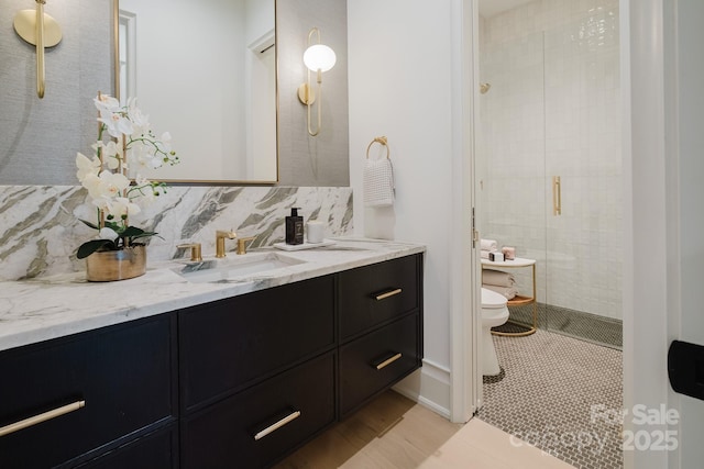 bathroom with vanity, tile patterned flooring, a shower stall, decorative backsplash, and toilet