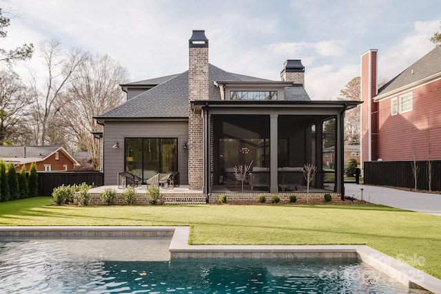 back of property with a yard, fence, a fenced in pool, and a sunroom