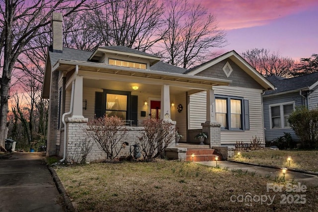 bungalow-style home featuring a porch and a chimney