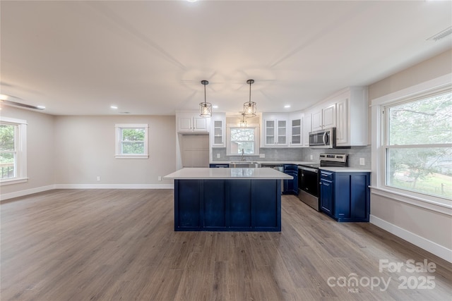 kitchen featuring blue cabinets, tasteful backsplash, appliances with stainless steel finishes, and light countertops