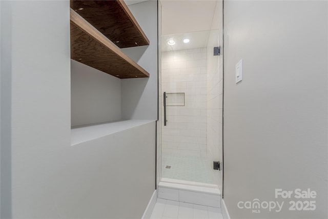 full bath featuring tile patterned floors, a shower stall, and baseboards