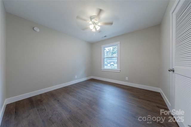 spare room featuring dark wood-style floors, baseboards, and ceiling fan