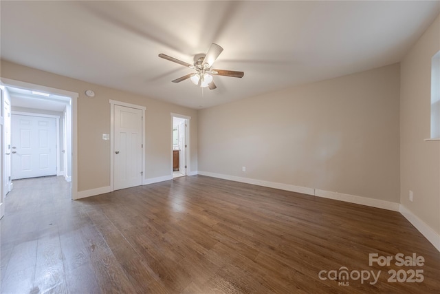 spare room featuring wood finished floors, baseboards, and ceiling fan